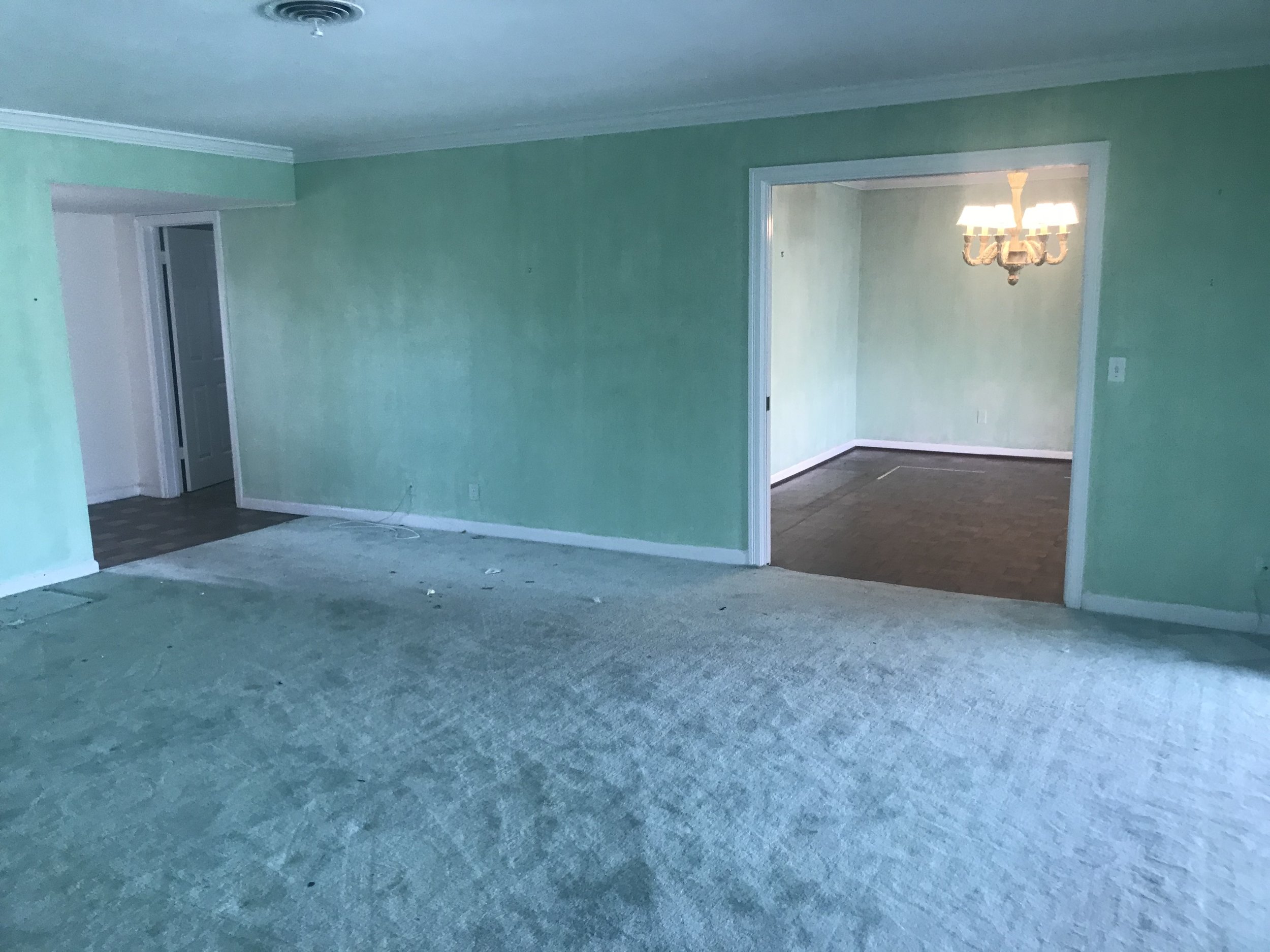 This view is standing in the doorway of the master suite and looking into the formal living area and current dining room space. This wall will be coming out as well as the left wall of the dining room.